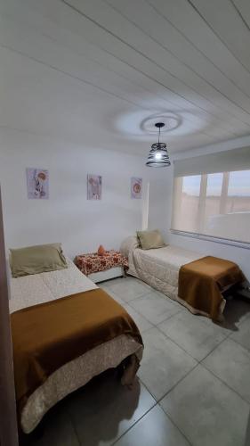 a bedroom with two beds and a window at El refugio de Marisela in Trevelín