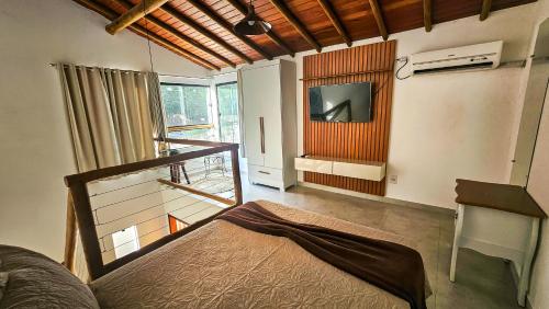 a bedroom with a bed and a tv in a room at Saíra Chalés in Lençóis