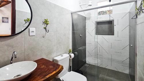 a bathroom with a shower and a toilet and a sink at Saíra Chalés in Lençóis