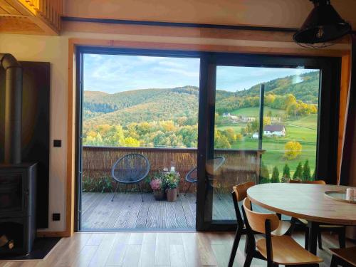 a room with a large sliding glass door with a table at Domek Ponad Mgłami in Laskowa