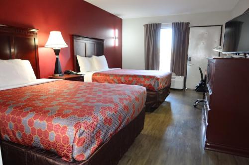 two beds in a hotel room with red walls at Econo Lodge Inn & Suites Evergreen in Evergreen