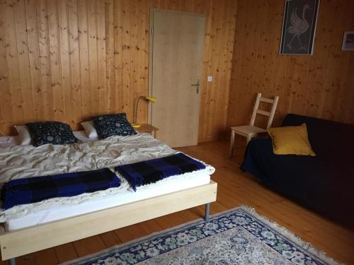 a bedroom with a bed and a chair in it at Grand chalet en Gruyère in Sorens