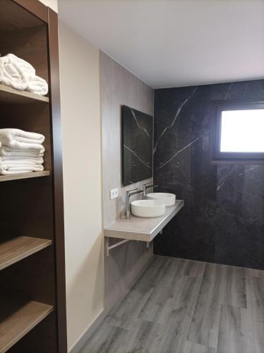 ein Badezimmer mit Waschbecken und schwarzer Wand in der Unterkunft Hotel Balfagón in Calanda