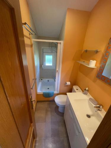 a small bathroom with a toilet and a sink at La casita in Pinilla del Valle