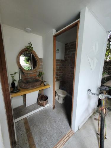 a bathroom with a toilet and a mirror at Hotel Capilla del sol in Garzón