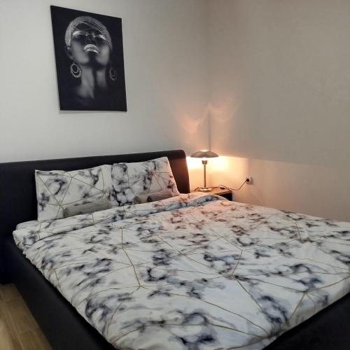 a bed in a bedroom with a black and white comforter at Cera luxe apartment in Soko Banja