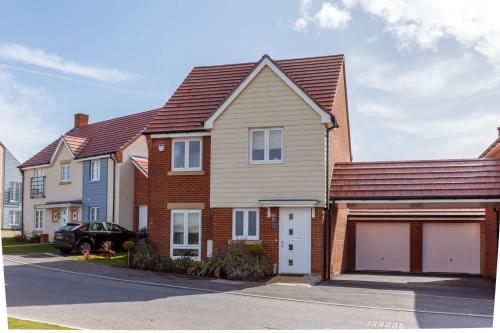 a house with two garage in a residential neighborhood at Heath Reach - Just a short distance to Tower Park in Poole