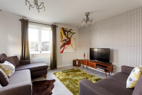 a living room with a couch and a flat screen tv at Heath Reach - Just a short distance to Tower Park in Poole