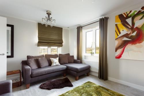 a living room with a couch and a window at Heath Reach - Just a short distance to Tower Park in Poole