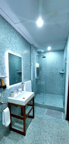 a bathroom with a sink and a shower at Hotel Plaza Yara in Manuel Antonio