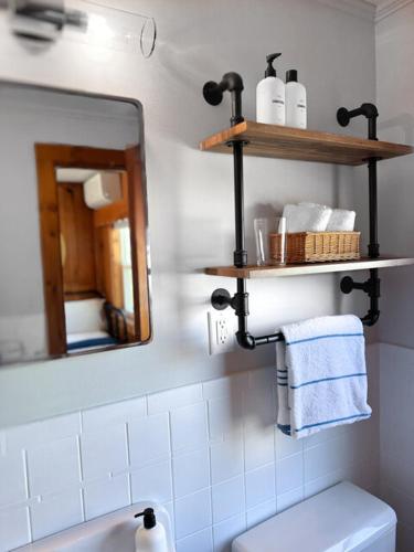 a bathroom with a sink and a mirror and a toilet at Cape Cod Motor Inn in South Yarmouth