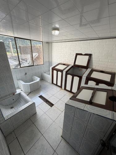 a room with a bathroom with two beds and a tub at Hostería Agoyan Deluxe in Ulba