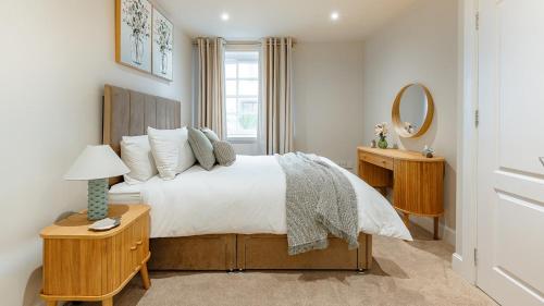 a bedroom with a large bed and a mirror at Creel Cottage, Lower Largo in Lower Largo