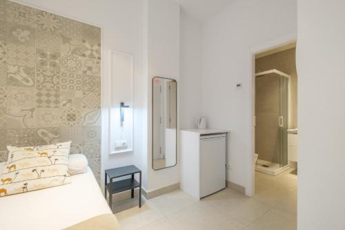 a white bedroom with a bed and a mirror at Comfortable Room close to City Centre in Valencia