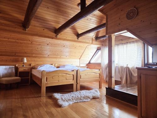 a bedroom with a bed in a wooden room at Camere de Inchiriat Ceahlau in Ceahlău