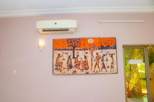 a painting hanging on a wall in a room at A4S Hotel in Ouagadougou