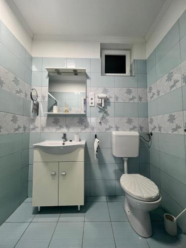 a bathroom with a toilet and a sink and a mirror at Napfény Apartman in Makó