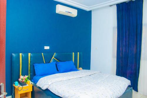 a blue bedroom with a bed with a blue wall at A4S Hotel in Ouagadougou
