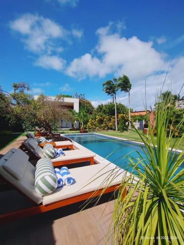 a swimming pool next to a villa at Villa Egeu Praia da Pipa in Pipa