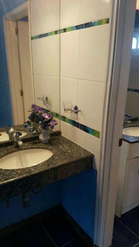a bathroom with a sink and a mirror and flowers at blue beach in Rocha