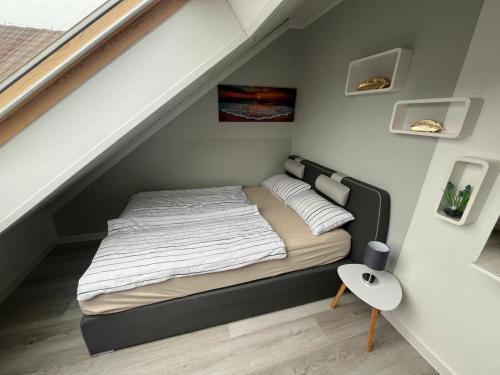 a small bedroom with a bed in the attic at Meeresbrise in Norden
