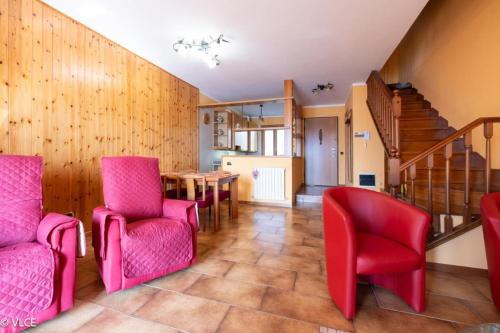 a living room with red chairs and a table at La Casetta di Pino in Varenna