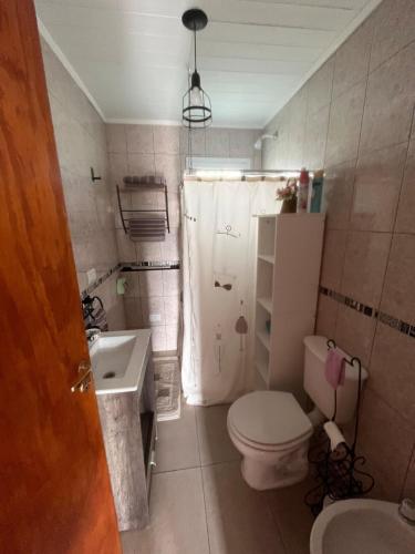 a small bathroom with a toilet and a sink at El refugio de Marisela in Trevelín