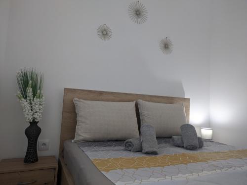 a bedroom with a bed with a vase of flowers on the wall at SokoSTAR Apartman in Soko Banja