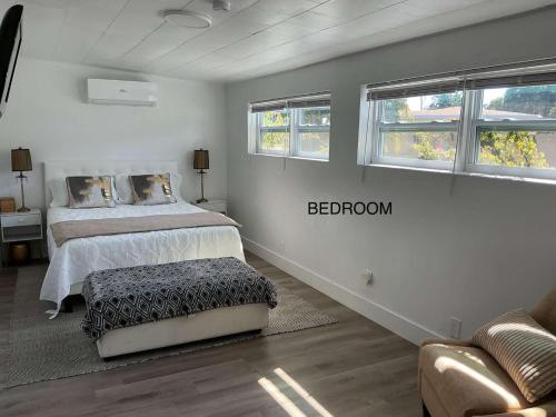 a bedroom with a bed and a couch and two windows at Modern Hard Rock Apartment in Miramar