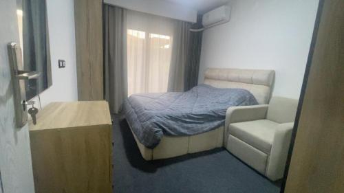 Un pequeño dormitorio con una cama y una silla. en The View - Garden View, en Sharm El Sheikh