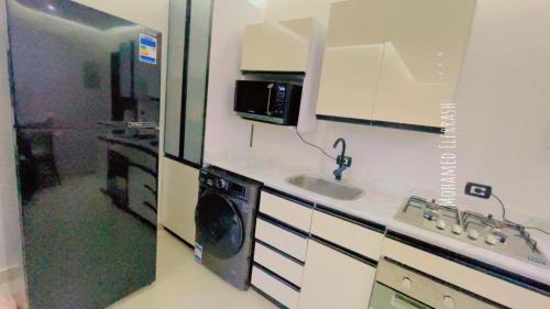 una cocina con fregadero y microondas en The View - Garden View, en Sharm El Sheikh