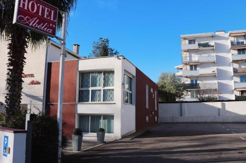 ein Gebäude mit einem Hotelschild neben einem Gebäude in der Unterkunft Hotel Abelia in Montpellier