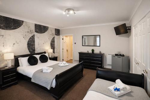 a bedroom with two beds and a television in it at The Mayfair Lodge & Family Suite in Hartlepool