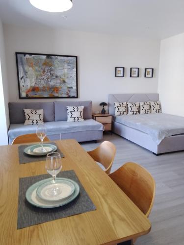 a living room with a table and a couch at Свіжі апартаменти в центрі міста новобудові на Проскурівське підпілля 110а in Khmelnytskyi