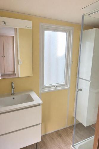 a bathroom with a sink and a window at Burträsk Camping & Stugby in Burträsk