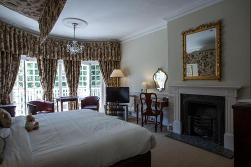 a bedroom with a white bed and a fireplace at Chateau La Chaire Hotel in Rozel