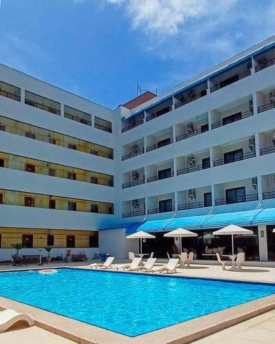 a large hotel with a swimming pool and chairs and umbrellas at Golden Beach Hotel in Fortaleza