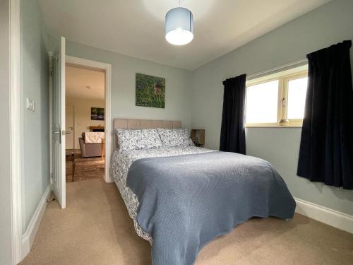 a bedroom with a bed with a blue blanket at Stag Cottage in Ilkeston