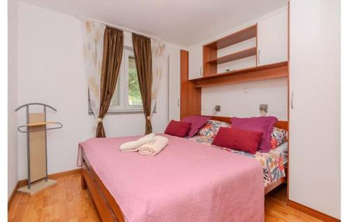 a bedroom with a pink bed and a window at Apartments Zaton Draga in Zaton