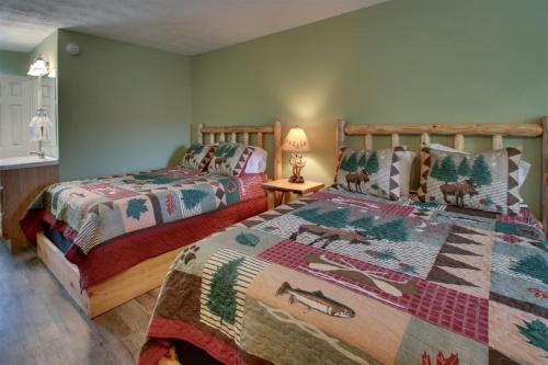 a bedroom with two beds and a table with a lamp at Bavarian Brook 7A in Helen