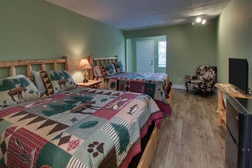 a bedroom with two beds and a flat screen tv at Bavarian Brook 7A in Helen