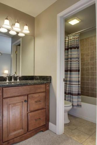 a bathroom with a sink and a toilet and a mirror at Bavarian Brook Condo 16 in Helen