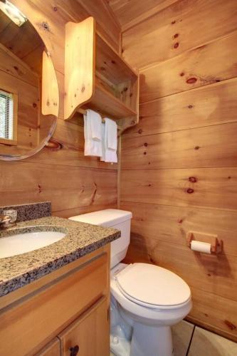 a bathroom with a toilet and a sink in a log cabin at Bavarian Hideaway 24 in Sautee Nacoochee