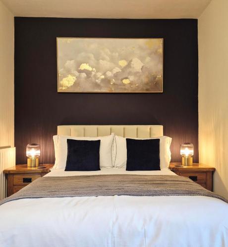 a bedroom with a large bed with two lamps on tables at Underhill Holiday Cottage in Whitby
