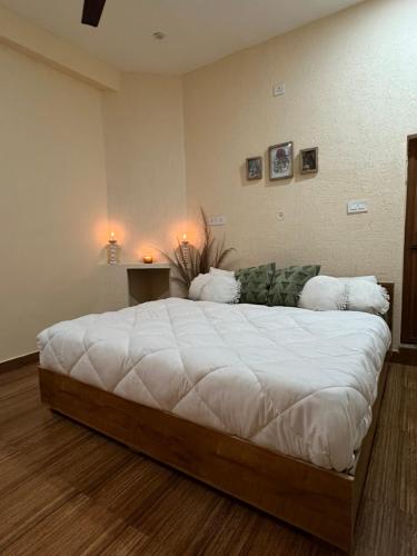 a bedroom with a large bed with white sheets at Yugm Homes Rishikesh in Narendranagar