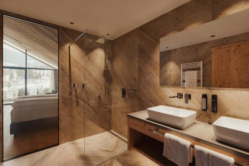 a bathroom with two sinks and a shower at Luxury B&B August in Ortisei