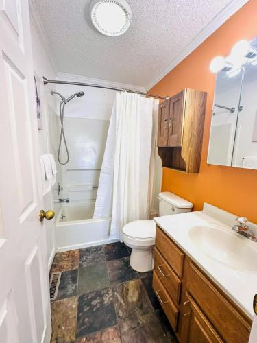 a bathroom with a toilet and a tub and a sink at Sunset and Chill Lakefront 3 Bed 2 Bath Hottub, Firepit Dock in Lake Ozark