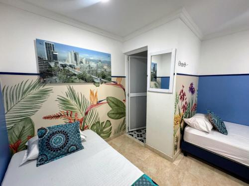 a bedroom with two beds and a mural on the wall at Casa Hotel Manco Mora in Medellín