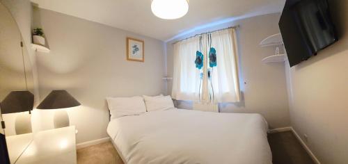 a bedroom with a white bed and a window at Modern luxury 3-bedroom guesthouse in Wigan in Wigan
