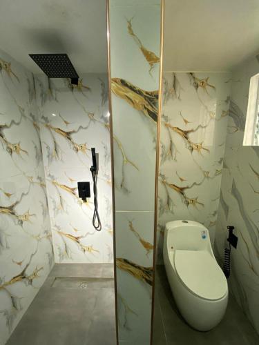 a bathroom with a toilet in the corner of a room at NVH2 Coron Palawan in Coron